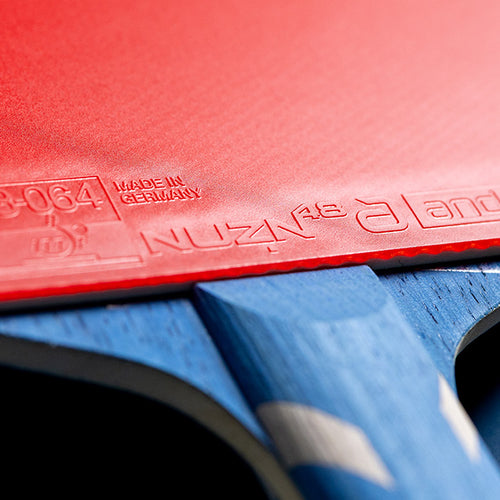 Close-up of red Andro NUZN 48 rubber fitted to a table tennis blade