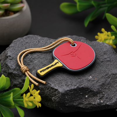 Powerkraft table tennis racket keychain on a dark stone display
