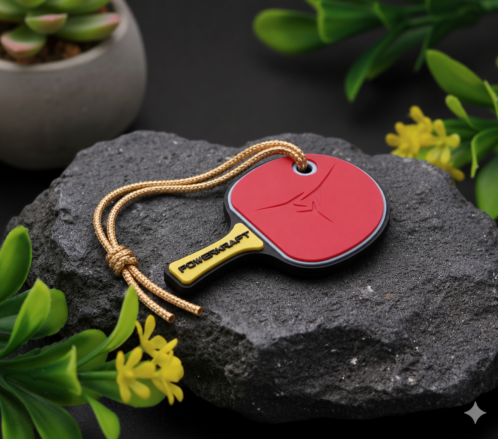 Powerkraft table tennis racket keychain on a dark stone display